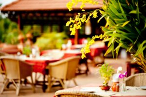 outdoor restaurant in asia with yellow orchid in foreground